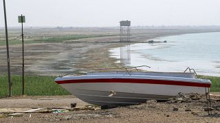توقف قارب بسبب انحسار خط المياه في بحيرة الحبانية المتضررة من الجفاف الشديد في محافظة الأنبار العراقية، في 11 آب / أغسطس 2023.