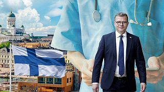 تصویر ترکیبی از مرکز شهر هلسینکی، پرچم فنلاند و اورپو نخست وزیر فنلاند