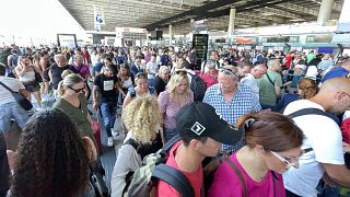 La folla si forma all'aeroporto di Catania, in Sicilia, dopo che un gran numero di voli è stato cancellato o ritardato a causa di una nube di cenere vulcanica dovuta all'eruzione dell'Etna.