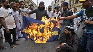 Radikális iszlamisták svéd zászlót égetnek a pakisztáni Karachiban 2023. július 7-én.