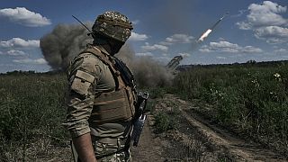 Украинский солдат наблюдает за тем, как система залпового огня "Град" выпускает снаряды с листовками в районе Бахмута, Донецкая область, Украина, воскресенье, 13 августа 2023