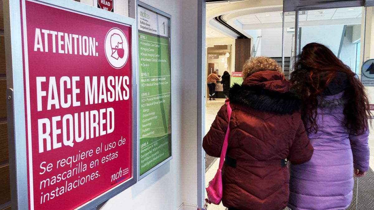 A sign announcing a face mask requirement is displayed at a hospital in Buffalo Grove, Ill., Friday, Jan. 13, 2023. 