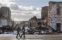 Ukrainian servicemen walk by a building destroyed by a Russian strike in Kupiansk, Ukraine, Monday, Feb. 20, 2023.