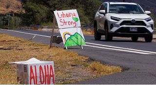 Local residents put up signs along the highway entering the fire ravaged town of Lahaina on the island of Maui in Hawaii, US, 15 August, 2023.