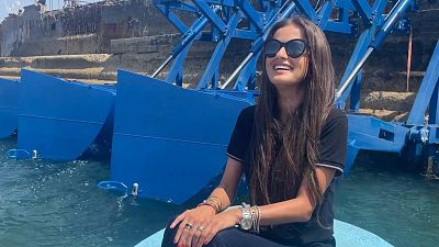 Inna Braverman sits infront of the Eco Wave Power station installed in Israel. 