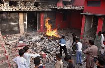 Fiatalok nézik a muszlimok által megrongált és felgyújtott egyik templomot