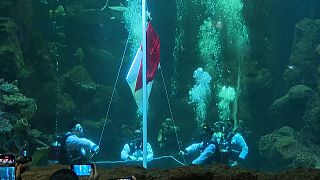 Indonesian flag being hoisted underwater