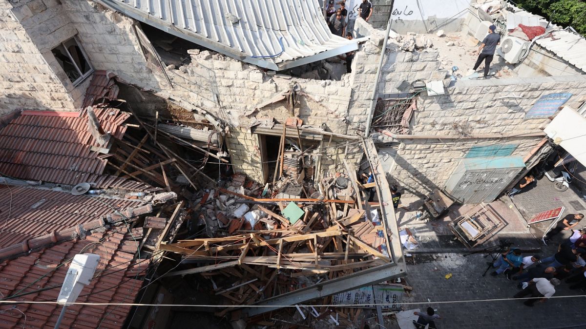 فلسطينيون يتفقدون الأضرار التي لحقت بمنزل في جنين بالضفة الغربية المحتلة في 17 أغسطس 2023، في أعقاب غارة عسكرية إسرائيلية.