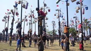 شارك الناس في مسابقة تسلق عمود مشحم كجزء من احتفالات يوم الاستقلال في شاطئ أنكول في جاكرتا