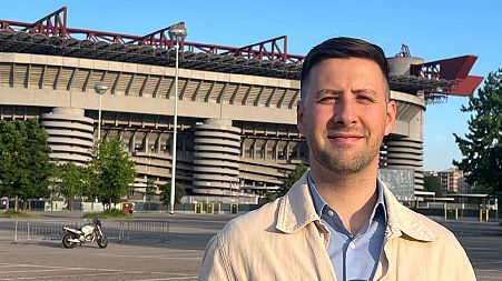 Euronews journalist Alessio Dell'Anna standing in front of Milan's San Siro stadium