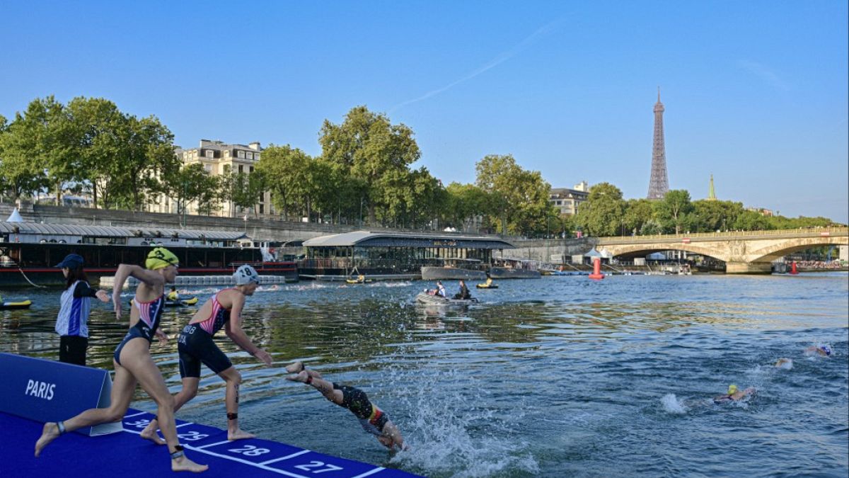 Atletas nadan en el río Sena en la primera etapa de la prueba de triatlón femenino para los Juegos Olímpicos de París 2024 en París, el jueves 17 de agosto de 2023.