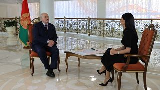 Belarus' President Alexander Lukashenko (L) speaks with Ukrainian journalist Diana Panchenko.