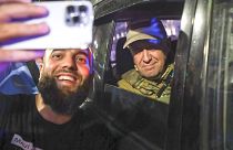 Yevgeny Prigozhin sits inside a military vehicle posing for a photo with a local civilian in a street in Rostov-on-Don, Russia, Saturday, June 24, 2023.