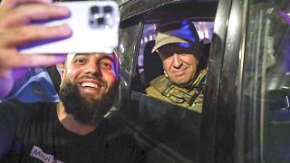 Yevgeny Prigozhin sentado en el interior de un vehículo militar posando para una foto con un civil local en una calle de Rostov del Don, Rusia, sábado 24 de junio de 2023.