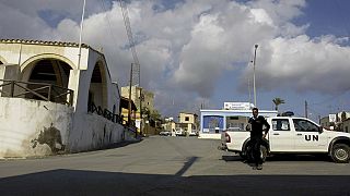 A UN police officer walks in front of a UN vehicle at the square of Pyla village at the UN buffer zone, outskirt of coastal city of Larnaca, Cyprus.