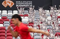 An athlete runs past cutouts of the games' mascot, Youhuu, a native Hungarian sheep, at the National Athletics Centre, Budapest, August 18, 2023