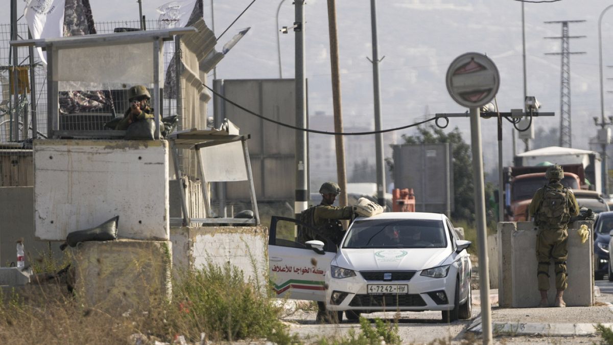 Израильские военные проводят досмотры автомобилей в поисках нападавших