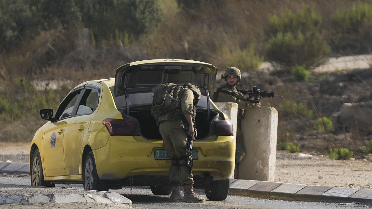 جنود إسرائيليون يفتشون سيارة في بلدة حوارة
