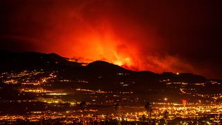 Flares are seen on the horizon as the fire advances through the forest toward the town of La Laguna and Los Rodeos airport on the Spanish island of Tenerife.