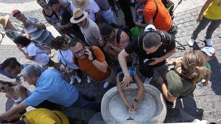 Egy szökőkútnál próbálnak hűsölni az emberek a Szent Péter téren, a Vatikánban 2023. augusztus 20-án
