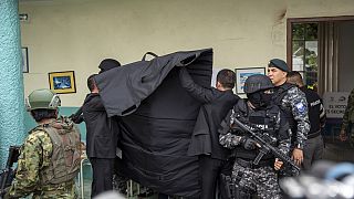 La policía cubre al candidato presidencial Christian Zurita, del "Movimiento Construye", mientras marca su papeleta en unas elecciones anticipadas en Quito, Ecuador