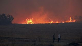 People watch the flames during a wildfire near the northeastern town of Alexandroupolis, Greece, Sunday, Aug. 20, 2023. 
