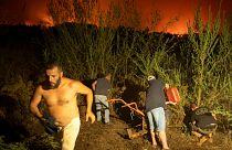 Local residents try to clean the forest to prevent it from flames as fire advances in La Orotava in Tenerife, Canary Islands, Spain on Saturday, Aug. 19, 2023.