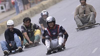 Soapbox cart rider races downhill during the Virada Cultural festival.