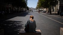 Una mujer se sienta a la sombra en las altas temperaturas en Marsella, sur de Francia, sábado, 19 de agosto de 2023.