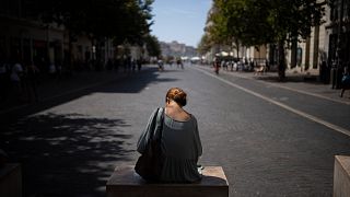 Una mujer se sienta a la sombra en las altas temperaturas en Marsella, sur de Francia, sábado, 19 de agosto de 2023.