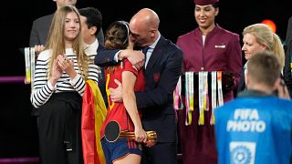 Futbol Federasyonu Başkanı Luis Rubiales, kadın futbolcuyu kucaklarken.