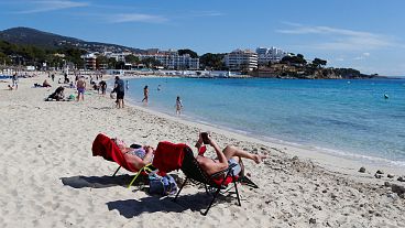 La gente disfruta del tiempo soleado en la isla balear de Mallorca.