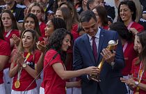 Spain's acting Prime Minister Pedro Sanchez holds the trophy next to Spain's Ivana Andres after their World Cup victory, at La Moncloa Palace in Madrid, August 22, 2023. 