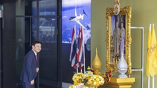 رئيس وزراء تايلاند السابق ثاكسين شيناواترا يقف أمام صورة للملك ماها فاجيرالونجكورن عند وصوله إلى مطار دون مويانغ في بانكوك، تايلاند، 22 أغسطس 2023.