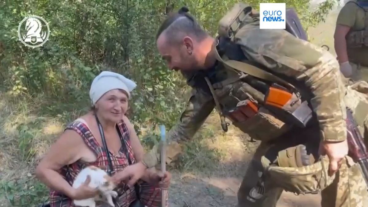 A Ukrainian soldier with one of the villagers rescued from Robotyne. 