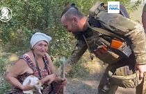 A Ukrainian soldier with one of the villagers rescued from Robotyne.