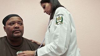 طبيبة تفحص مواطنا في مركز يقدم الخدمات الطبية لذوي الدخل المنخفض في مدينة نيويورك