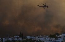 A helicopter operates over a wildfire burning in Gennadi village, on the Aegean Sea island of Rhodes