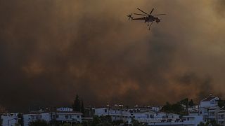 A helicopter operates over a wildfire burning in Gennadi village, on the Aegean Sea island of Rhodes