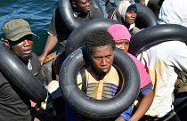 Migrantes que tentam fugir para a Europa são transferidos do seu pequeno barco para uma embarcação da guarda costeira tunisina, no mar entre a Tunísia e a Itália, a 10 de agosto.