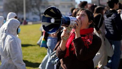 Un manifestante grita por un megáfono durante una manifestación de Viernes por el Futuro en Portugal.