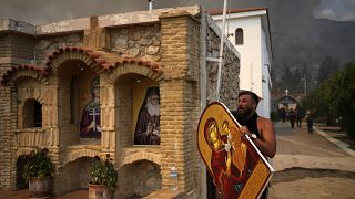Ein Mann in Acharnes bei Athen versucht eine Ikone aus einem Kloster in Sicherheit zu bringen am 234. August 2023