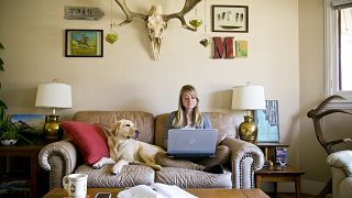 جيليان موروني تعمل من غرفة معيشتها برفقة كلبها، ايداهو الولايات المتحدة.