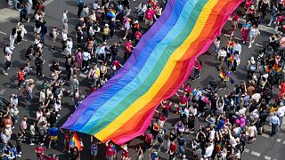 People hold a rainbow flag as they attend the 45th Berlin Pride Parade for Christopher Street Day (CSD) in Berlin, Germany, Saturday, July 22, 2023. 