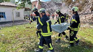 Сотрудники ГСЧС выносят тело жертвы атаки "Шахеда", Ромны, Сумская область, 23 августа 2023.