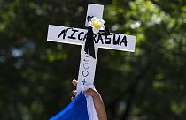 Manifestantes alzan una cruz con la palabra Nicaragua