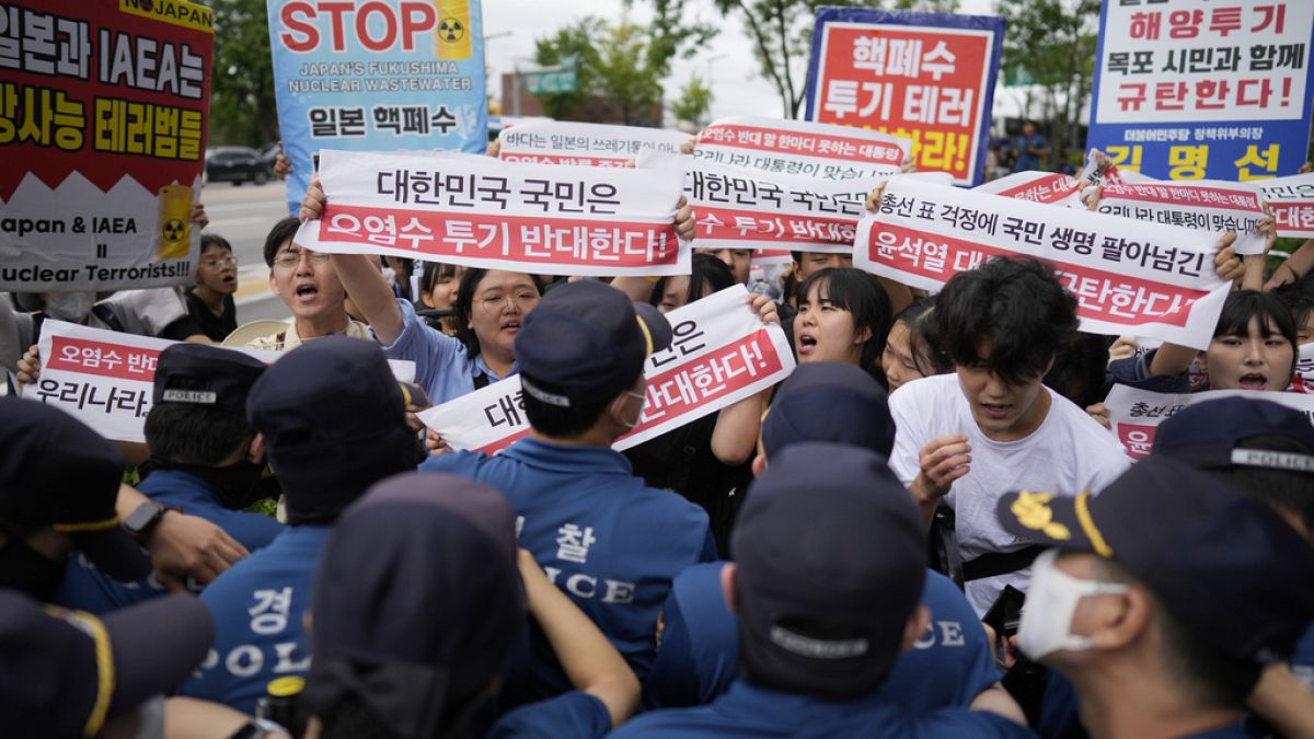 Los manifestantes sostienen carteles en el exterior de un edificio que alberga la embajada japonesa, en Seúl, Corea del Sur, el jueves 24 de agosto de 2023.