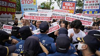 Los manifestantes sostienen carteles en el exterior de un edificio que alberga la embajada japonesa, en Seúl, Corea del Sur, el jueves 24 de agosto de 2023.
