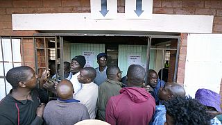 Eleitores aguardam à entrada de uma assembleia de voto em Harare, Zimbabué