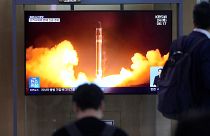 Dél-koreai járókelők nézik egy északi rakétakilövés képeit